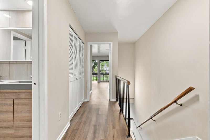 Hallway and stairs down with wood flooring at 7703 Las Palmas Way