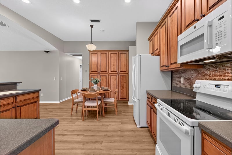 Kitchen with wood cabinets and dining nook at 1955 GUARDED Way, Fleming Island, FL 32003