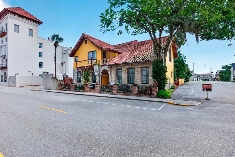 Street view of the yellow building and iron fence at 115 Cordova St, St. Augustine, FL