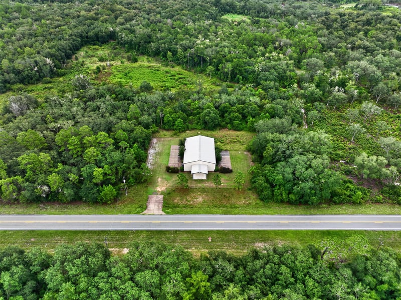 Drone aerial of the building and front lawn from the road at 1038 County Rd 315, Melrose