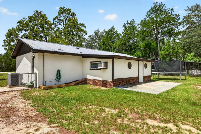 Rear exterior with carport and driveway area at 6757 Deer Springs Rd, Keystone Heights, FL 32656