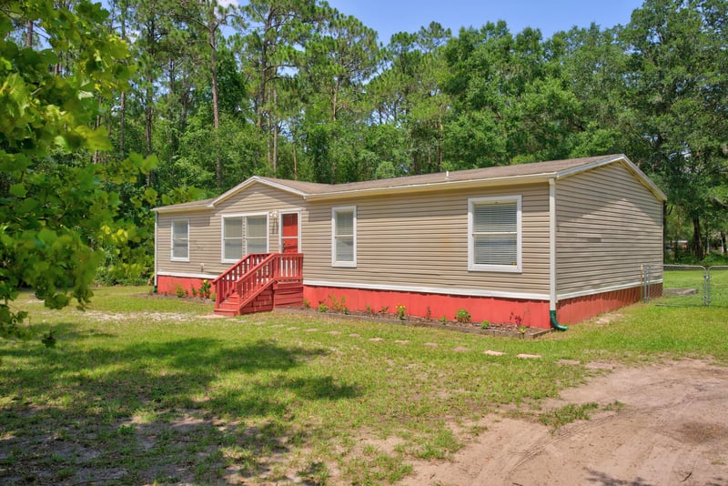 Front exterior with red accent skirting at 2549 Snapdragon Ave, Middleburg, FL 32068