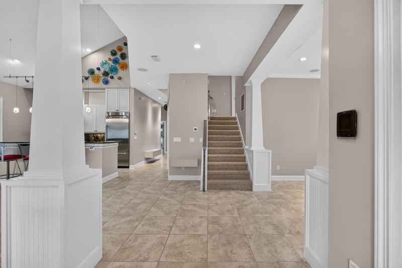 Entry hall with staircase and open kitchen view at 117 Island Cottage Way, St. Augustine, FL 32080