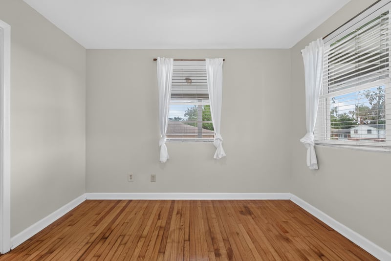 Bedroom with wood floors and curtained window at 217 Baisden Rd, Jacksonville, FL 32218