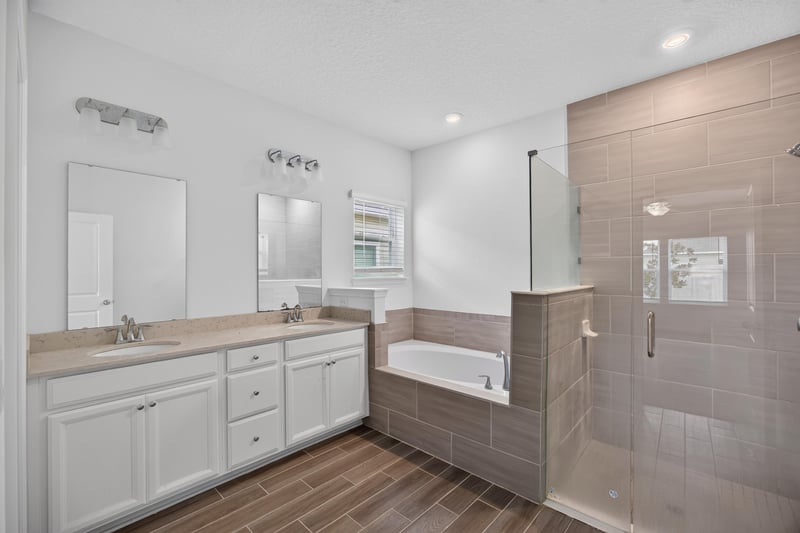 Primary bathroom with dual vanity and soaking tub, virtually staged at 9905 Ansley Lake Dr, Jacksonville, FL