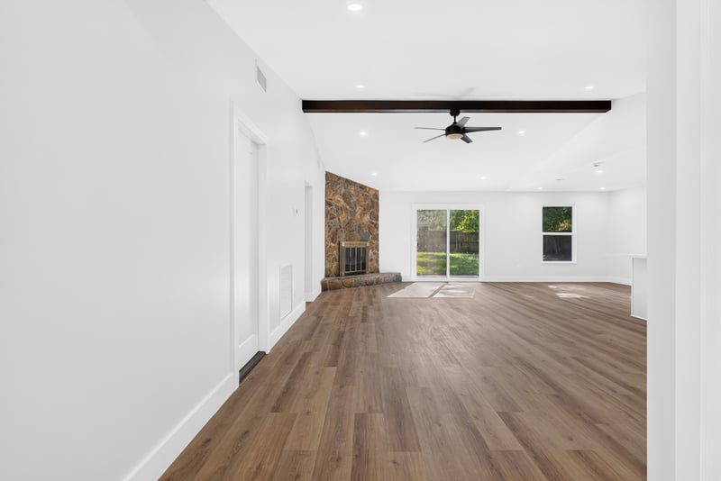 Empty living area with wood-look flooring and vaulted ceiling at 8453 Boysenberry Ln W, Jacksonville, FL