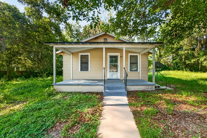 Front exterior with covered porch and wooded yard at 2372 2nd Ave, Jacksonville, FL 32208