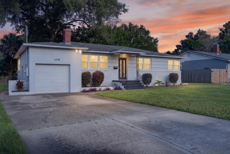 Front exterior at day-to-dusk with garage and lit entry at 6338 Mercer Cir W, Jacksonville, FL