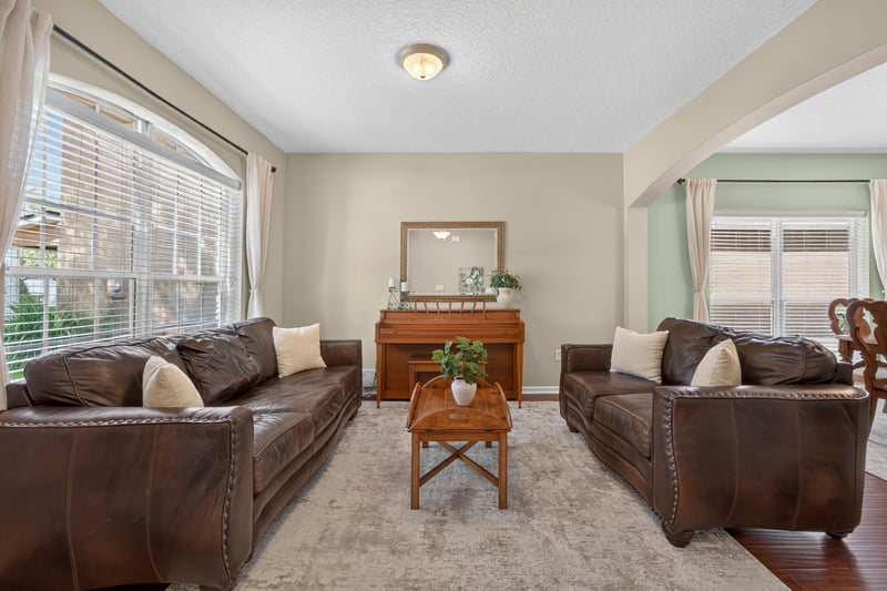 Living room with leather sofas and a large front window at 3660 Middlebrook Dr, Orange Park, FL 32065
