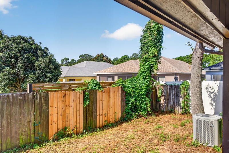 Backyard with wood fence and trees at 8010 International Village Dr, Jacksonville, FL 32277