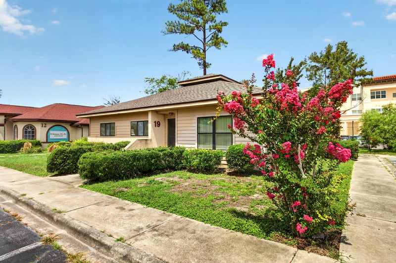Front entrance with landscaping and flowering shrub at 1543 Kingsley Ave #19, Orange Park, FL 32073