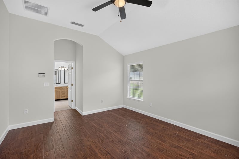 Empty room with archway and wood-look floor at 706 Bonaparte Dr, Jacksonville, FL 32218