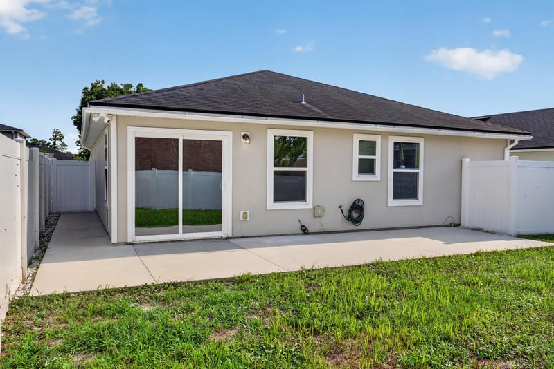 Backyard view with sliding door and patio at 7253 Townsend Village Ct, Jacksonville, FL