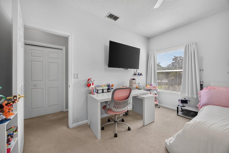 Bedroom with mounted TV and window at 2875 Pebblewood Ln, Orange Park, FL 32065