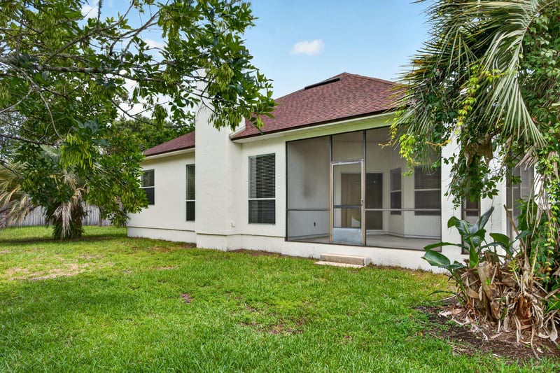 Back exterior with screened porch and palm trees at 2480 Ridge Will Dr, Jacksonville, FL 32246