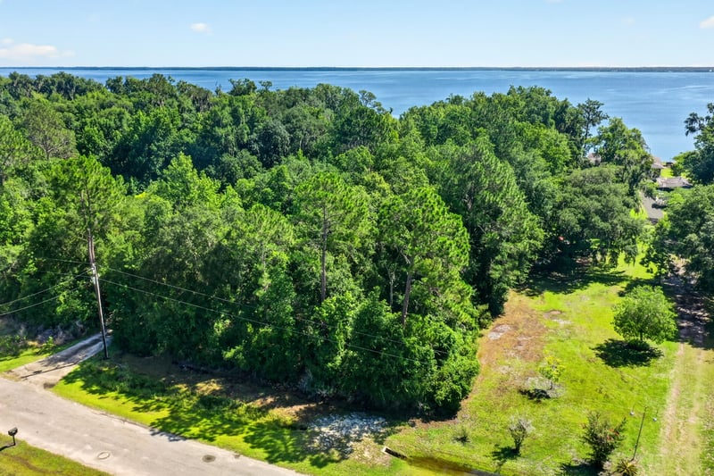 Aerial view of the wooded lot with the river in the distance at 110 River Shores Rd, Palatka, FL 32043