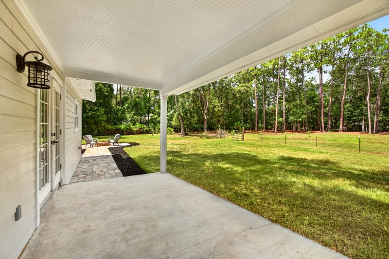 Covered patio with view of backyard lawn at 1161 Whispering Pines Rd, Jacksonville, FL 32259