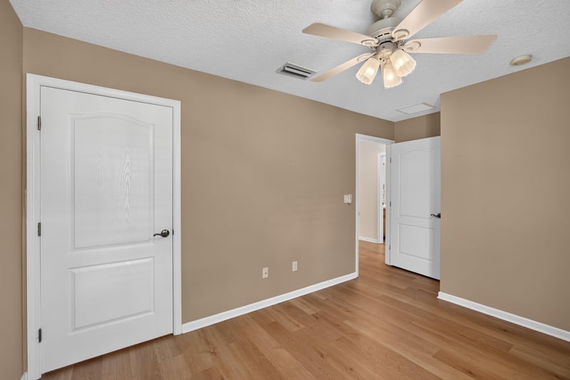 Hallway with tan walls and wood floors at 2131 E Stone Creek Dr, Fleming Island, FL
