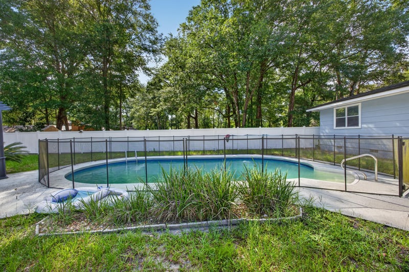 Backyard pool with fence and open lawn at 892 Branscomb Rd, Green Cove Springs, FL