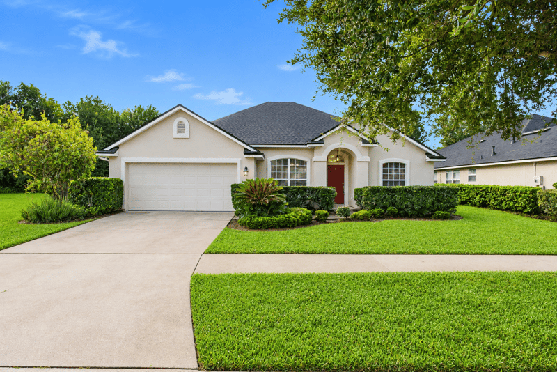 Driveway and two-car garage with red front door at 14187 Big Spring St, Jacksonville, FL 32258