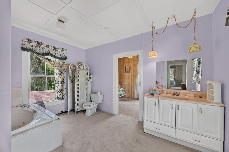 Bathroom with lavender walls and vanity at 1173 US-17, Satsuma, FL 32189