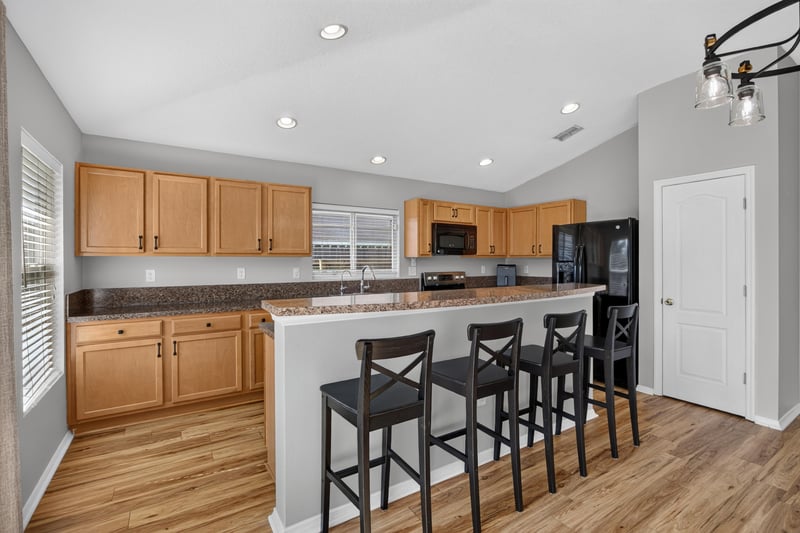 Kitchen with bar seating and wood cabinets at 7545 Lirope St, Jacksonville, FL 32244