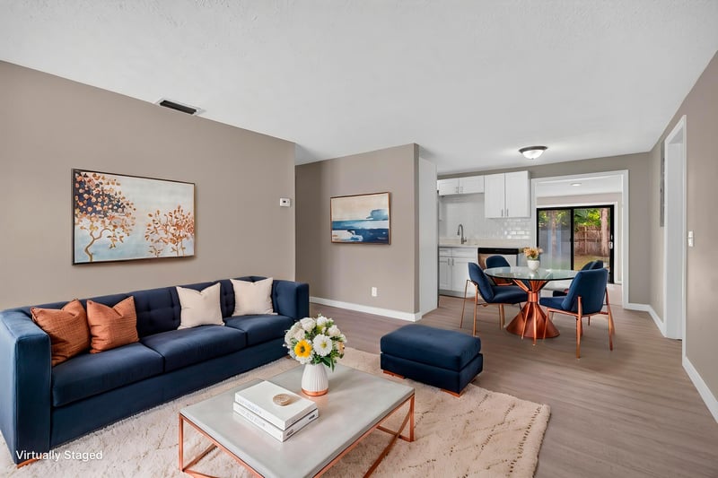 Virtually staged living room with blue sofa and dining area at 184 Draco St, Orange Park, FL 32073
