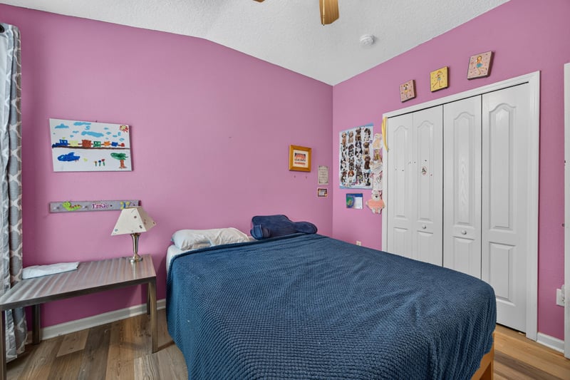 Bedroom with pink walls and closet doors at 2065 Creekmont Dr