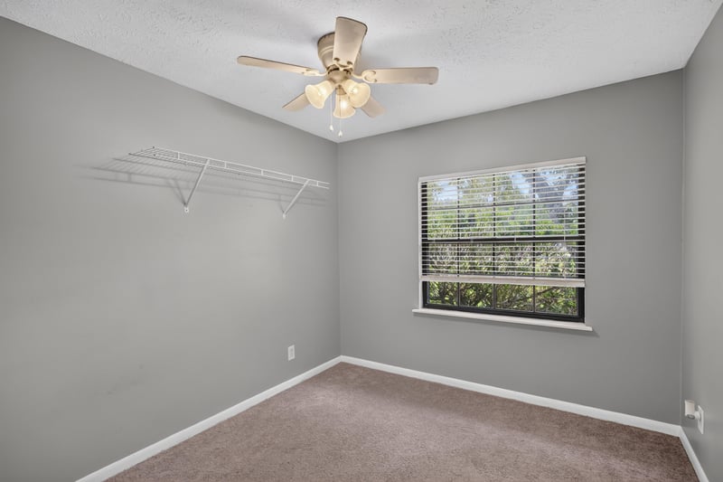 Carpeted bedroom with ceiling fan and window at 6757 Deer Springs Rd, Keystone Heights, FL 32656
