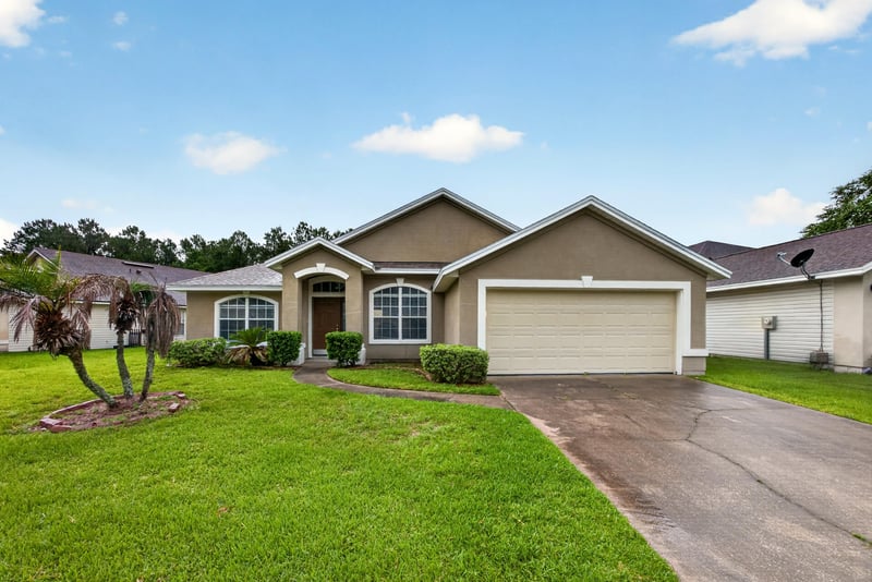Front exterior with driveway and palm trees at 706 Bonaparte Dr, Jacksonville, FL 32218