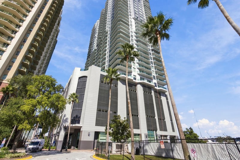 Drone view of the condo tower exterior and palm-lined entrance, photographed by Megapixeler on Riverplace Blvd, Jacksonville
