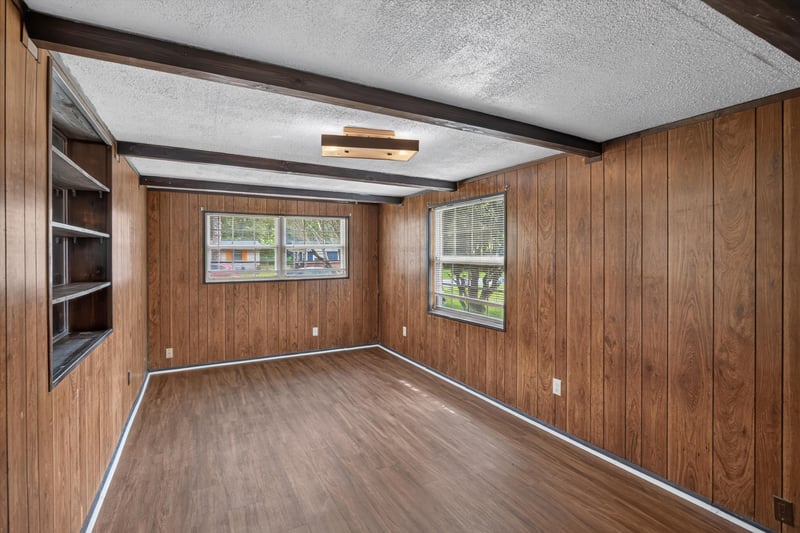 Wood-paneled den with beamed ceiling and bookshelf at 5812 Tampico Rd, Jacksonville, FL 32244