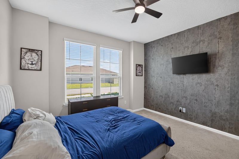 Secondary bedroom with wall-mounted TV at 9942 Lovage Ln, Jacksonville, FL 32219