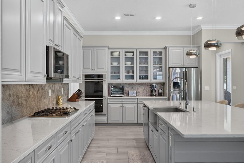 Kitchen with double wall ovens and tile backsplash at 22 Azura Point