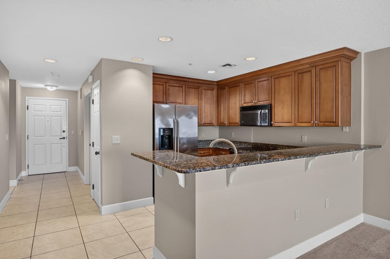 Kitchen pass-through to hallway with wood cabinets at 1478 Riverplace Blvd 1904, Jacksonville, FL 32207