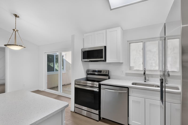 Kitchen with pendant light and window, virtually staged at 8177 Virgo St, Jacksonville, FL 32216