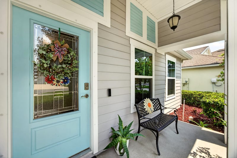 Front entry with teal door and covered porch bench at 85 Amia Dr, St. Augustine, FL 32086