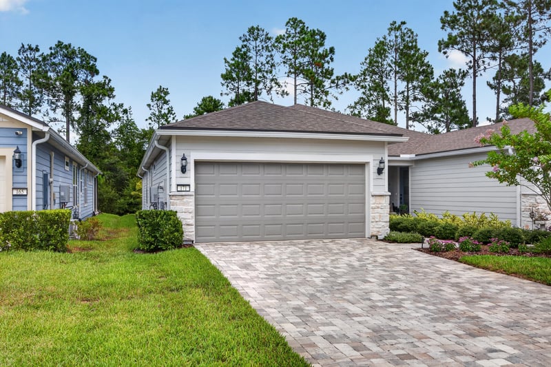 Front exterior with paver walkway and mature trees at 171 Oyster Shell Ter, Nocatee, FL 32081