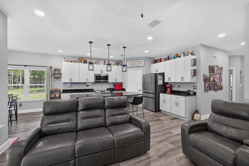Living room open to kitchen with pendant lighting at 2817 Camel Cir, Middleburg, FL
