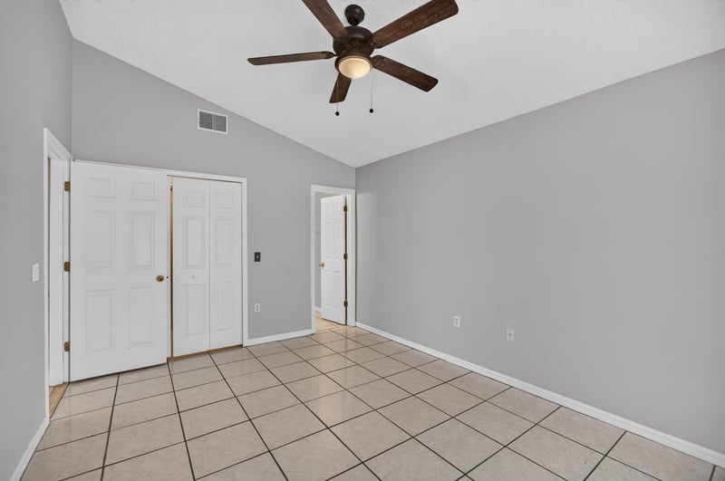 Bedroom with tile floor and double closet doors at 7329 Lawn Tennis Ln, Jacksonville, FL