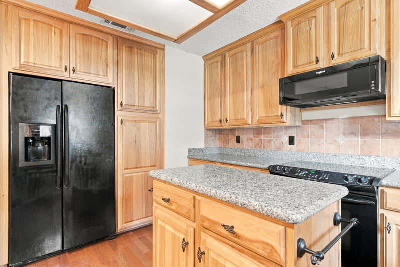 Kitchen view toward black refrigerator and cabinetry at 2915 Trenton Ct, Orange Park, FL