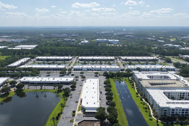 Aerial view toward a multi-story building beyond the office park at 10550 Deerwood Park Blvd, Jacksonville, FL 32256
