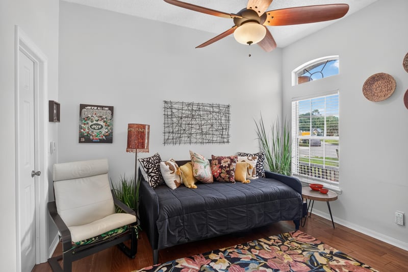 Sitting room with dark sofa and area rug at 1820 Burgess Hill Dr E, Jacksonville, FL