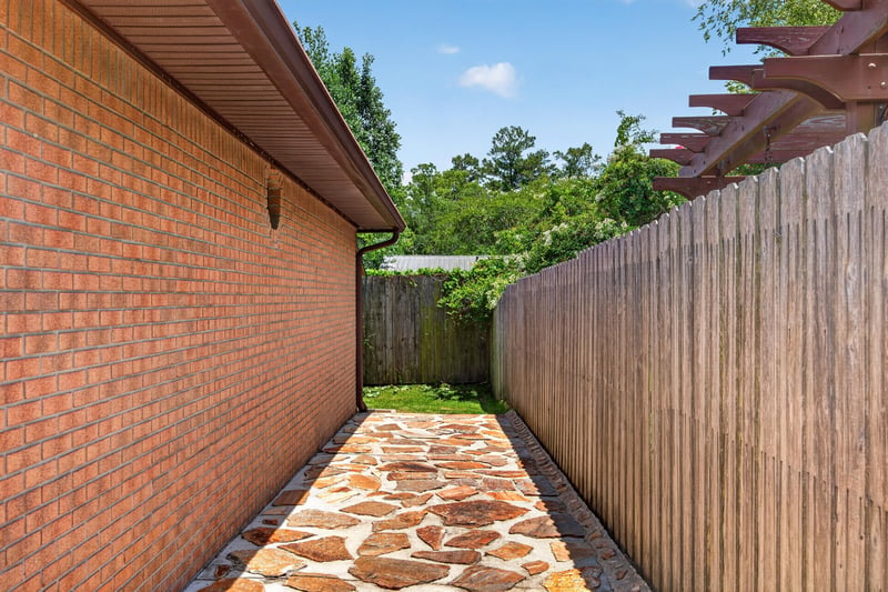 Side yard with brick wall, fence, and stone walkway at 2460 San Sago Ln, Jacksonville, FL