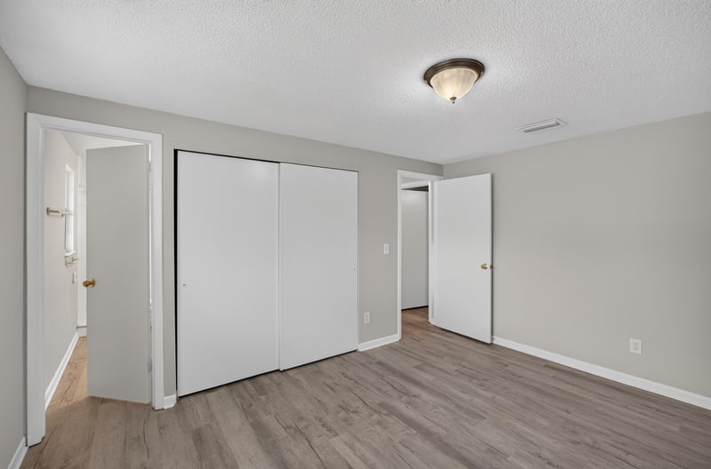 Bedroom with closet doors and wood floors at 1435 Undine Ave, Jacksonville, FL