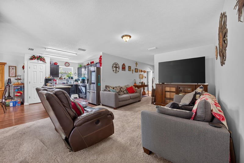 Family room with recliner sofa and carpet at 518 Matecumbe Ct, Macclenny, FL