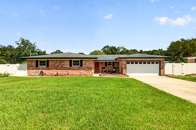 Front exterior with wide lawn and brick facade at 6059 Karen St, Jacksonville, FL 32244