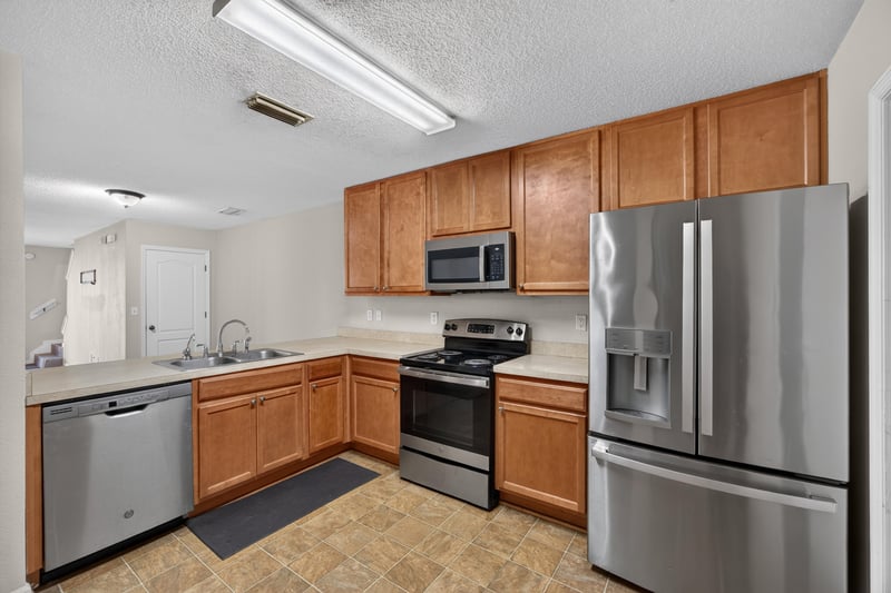 Kitchen with stainless refrigerator and dishwasher at 7723 Playschool Ln, Jacksonville, FL