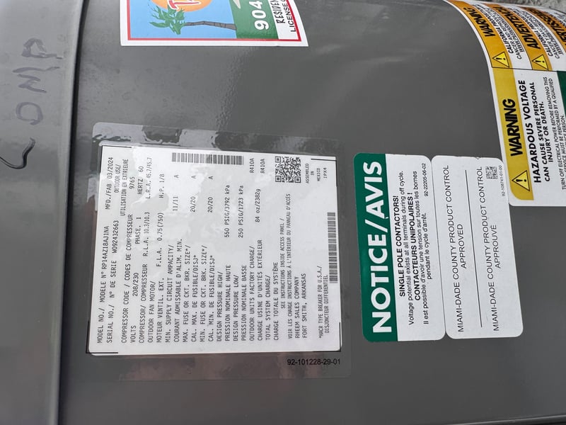 AC unit nameplate and hazard notice sticker at 11700 New Kings Rd, Jacksonville, FL 32219