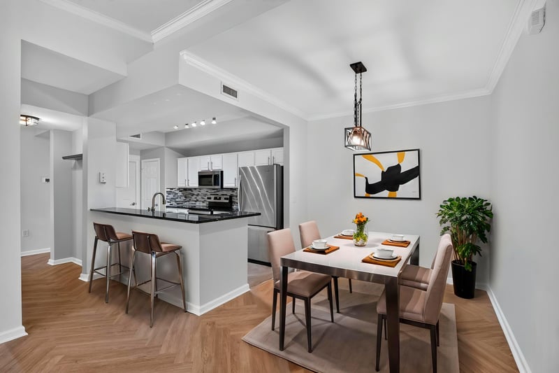 Virtually staged kitchen with dining table and bar seating at 10075 Gate Pkwy unit 1905, Jacksonville, FL 32246